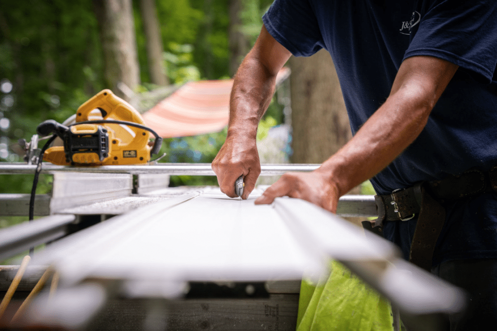 Man adjusting siding with powertools.